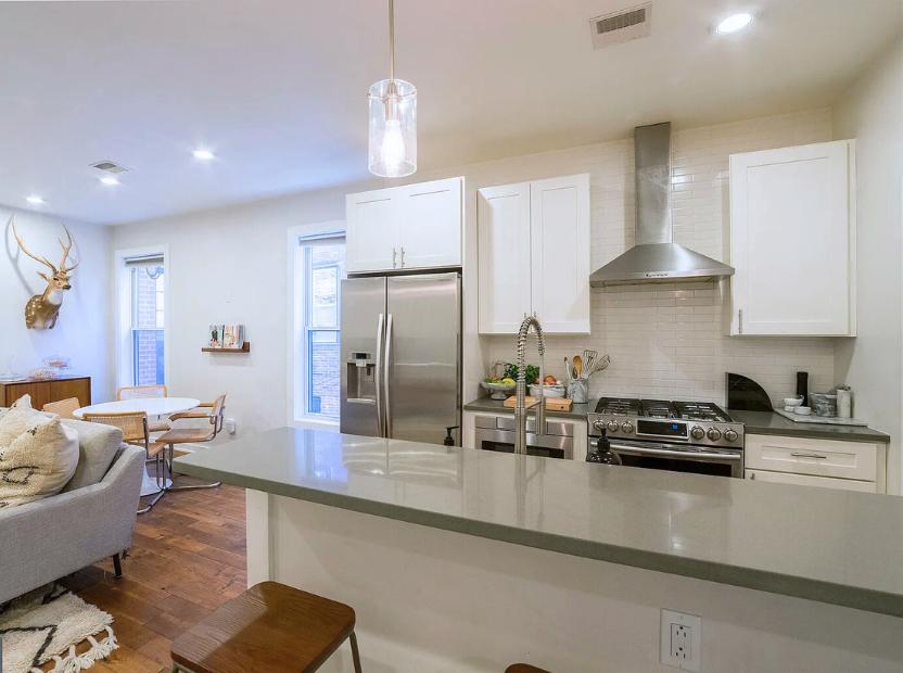 a modern kitchen and dining room at a remodeled home in philadelphia after a 203k loan consultancy with atlas consultation